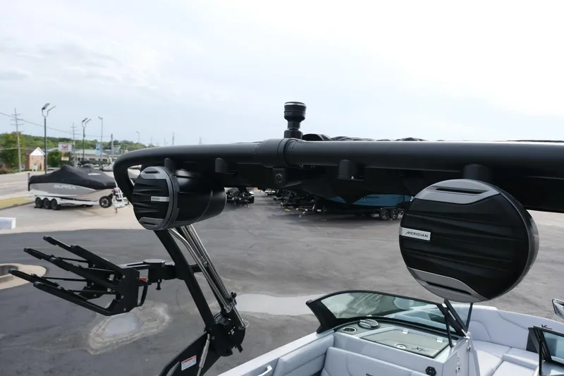 Slide: The Image of 2026 MasterCraft XT24 boat with Meridian speakers and wakeboard rack, parked outdoors. - 27