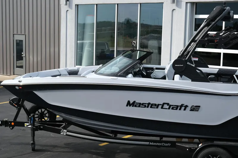 Slide: The Image of 2026 MasterCraft XT24 boat parked outside a modern building. - 3