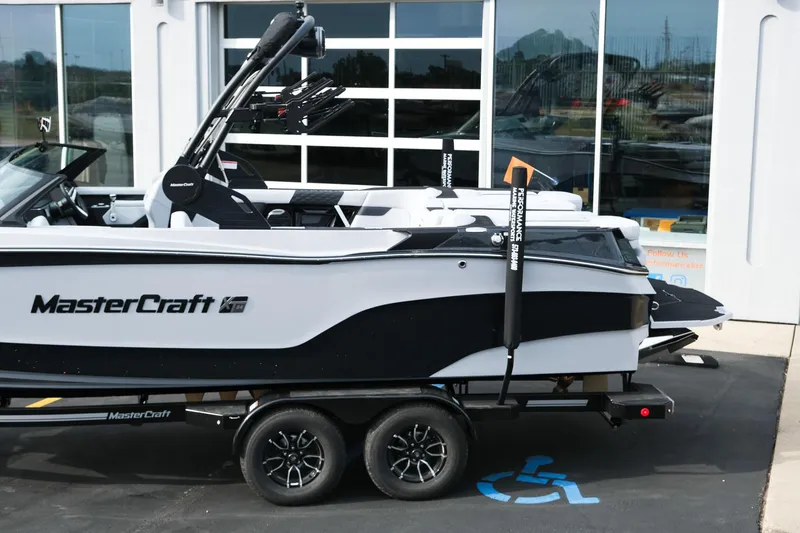 Slide: The Image of 2026 MasterCraft XT24 boat on trailer, parked outside a showroom. - 4