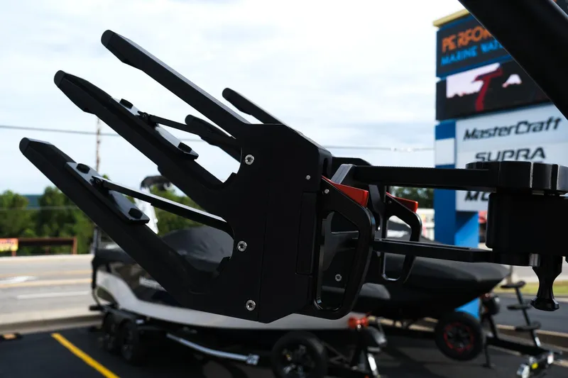 Slide: The Image of 2026 MasterCraft XT24 boat with wakeboard rack, parked at dealership. - 46