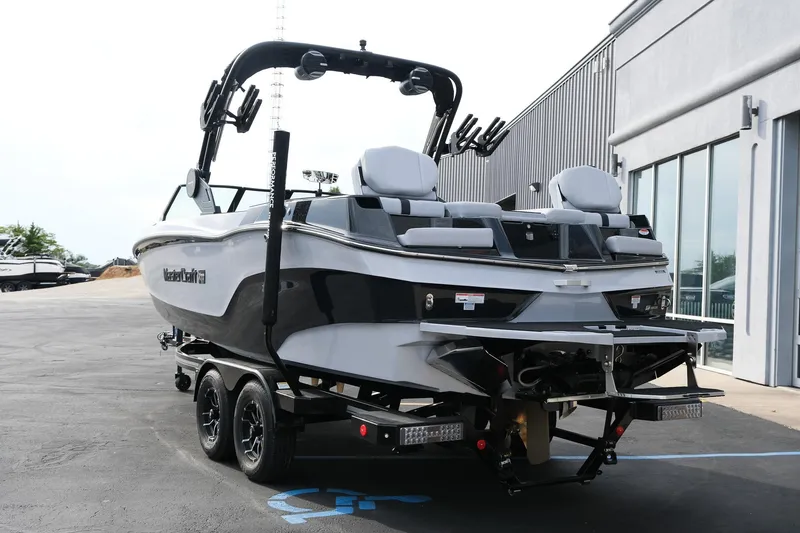 Slide: The Image of 2026 MasterCraft XT24 boat on trailer, parked outside a building. - 5