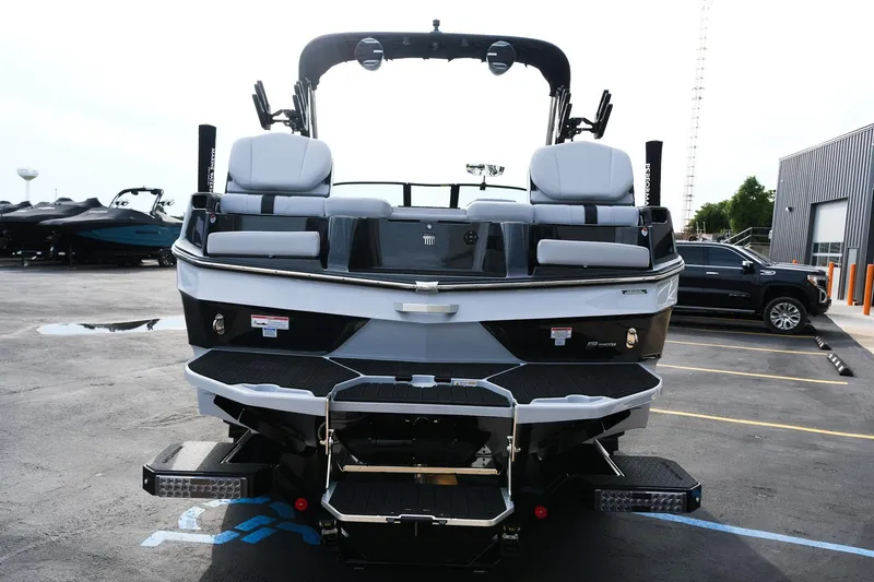 Slide: The Image of 2026 MasterCraft XT24 boat, rear view in a parking lot, showcasing sleek design and seating. - 6