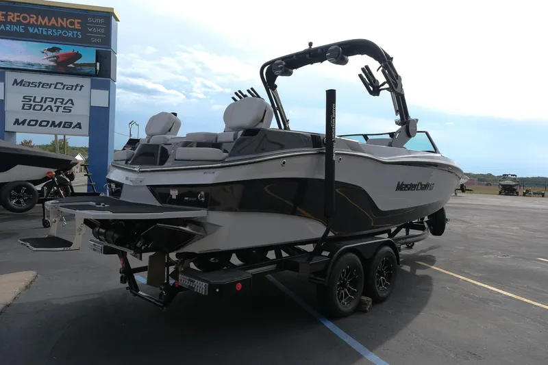 Slide: The Image of 2026 MasterCraft XT24 boat on trailer at marine dealership. - 7