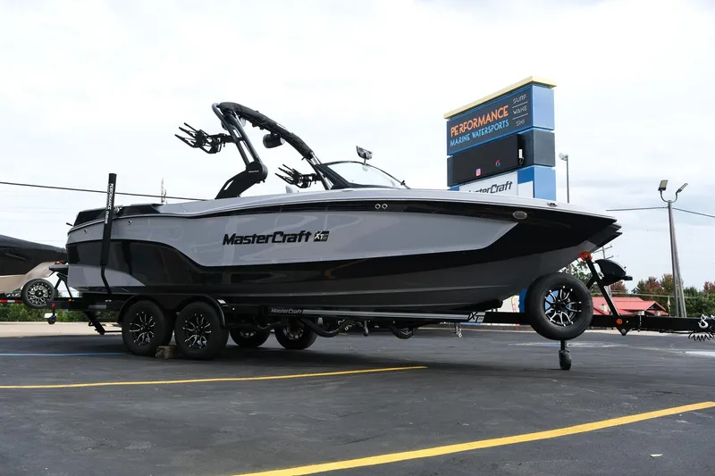 Slide: The Image of 2026 MasterCraft XT24 boat on trailer at Performance Marine Watersports dealership. - 8