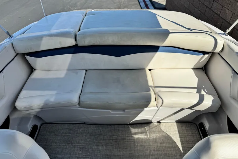 Slide: The Image of 2010 Four Winns H210 boat interior with cushioned seating and carpeted floor. - 15