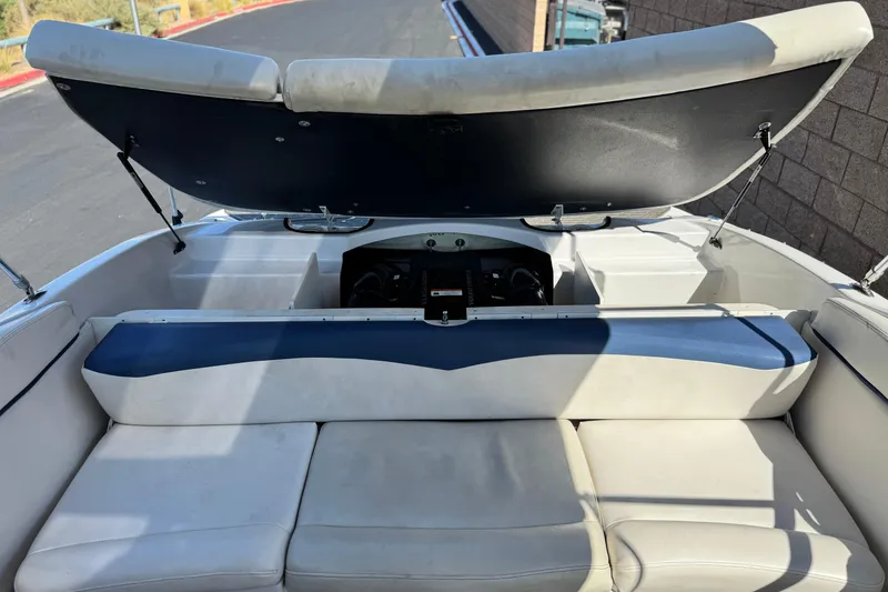 Slide: The Image of 2010 Four Winns H210 boat interior with open engine compartment and cushioned seating. - 16