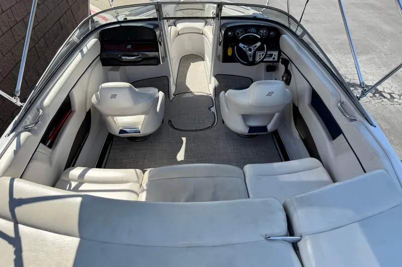 Slide: The Image of 2010 Four Winns H210 boat interior with white seating and steering console. - 18