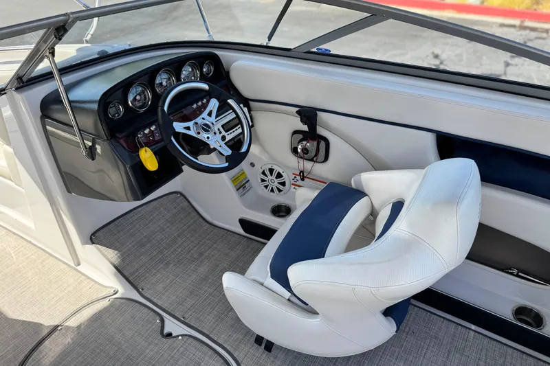 Slide: The Image of 2010 Four Winns H210 boat cockpit with steering wheel and white seating. - 21