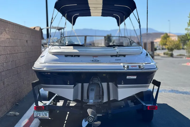 Slide: The Image of 2010 Four Winns H210 boat on trailer, rear view, parked outdoors. - 4