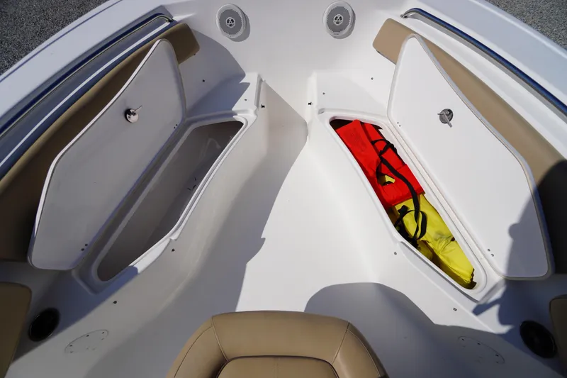 Slide: The Image of 2016 Tidewater 220 LXF boat storage compartments with life jackets. - 10
