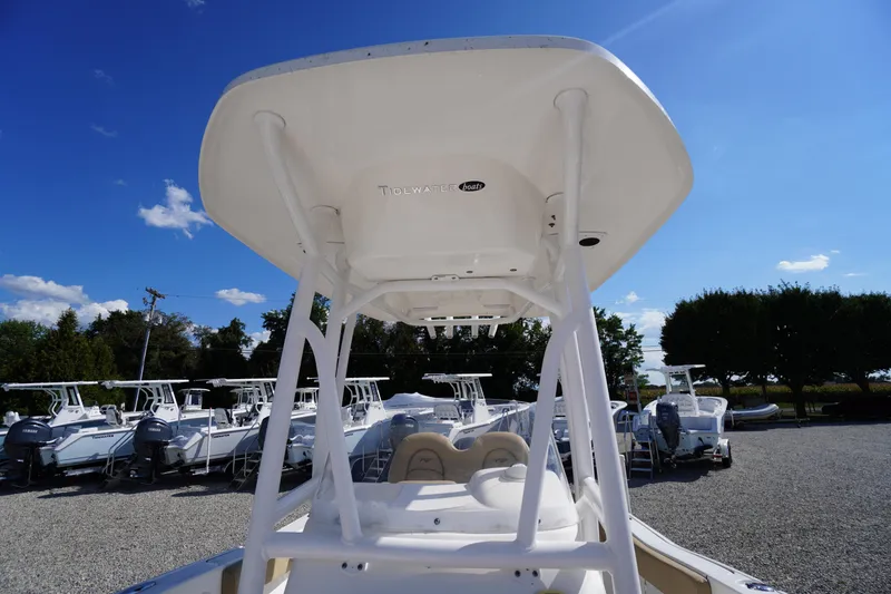 Slide: The Image of 2016 Tidewater 220 LXF boat with T-top, parked in a sunny outdoor lot. - 11