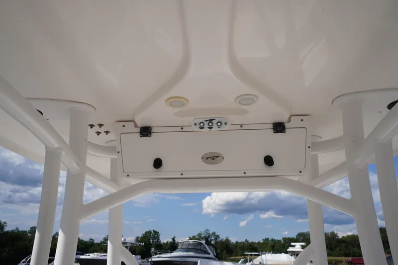 Slide: The Image of 2016 Tidewater 220 LXF boat T-top with storage compartment, under a clear sky. - 13