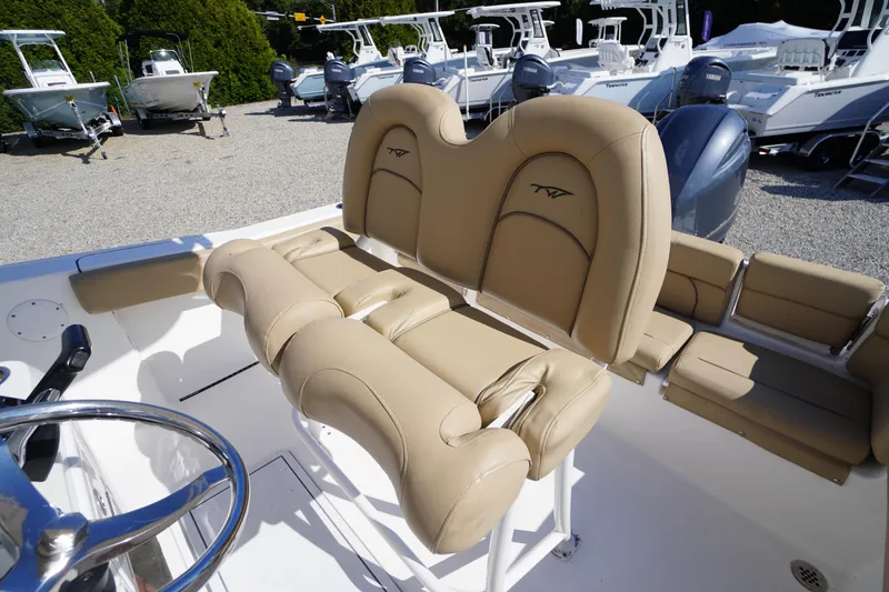 Slide: The Image of 2016 Tidewater 220 LXF boat with tan seating and steering wheel, displayed outdoors. - 22