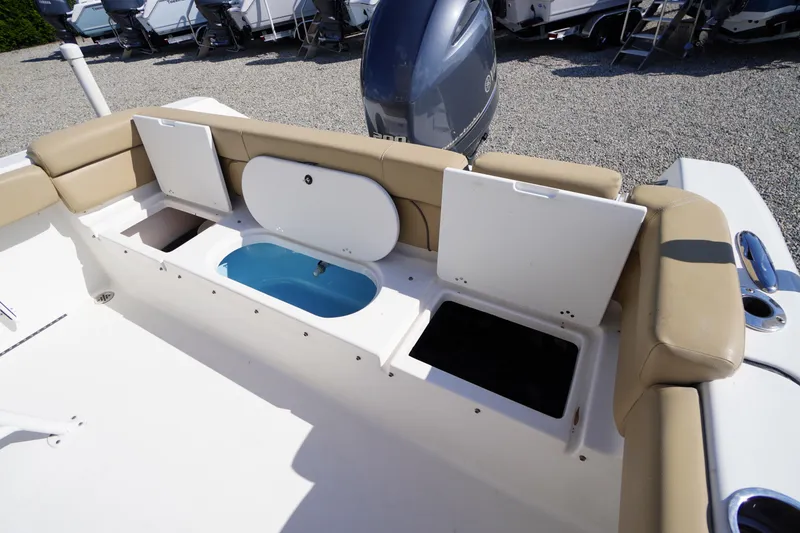 Slide: The Image of 2016 Tidewater 220 LXF boat interior with open storage compartments and cushioned seating. - 27