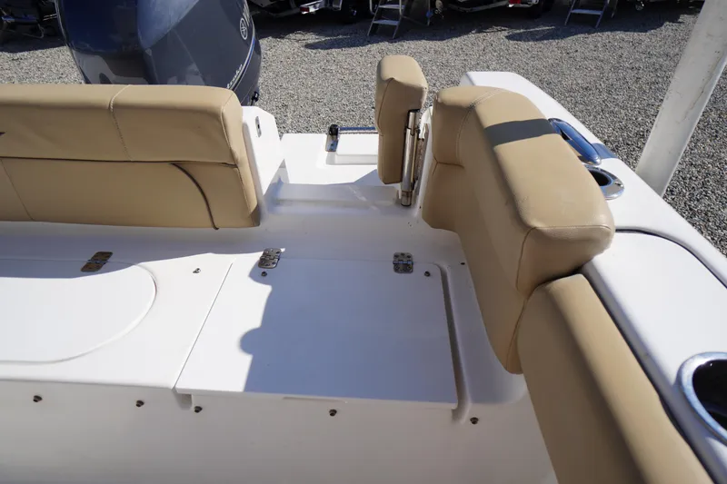 Slide: The Image of 2016 Tidewater 220 LXF boat interior with beige seating and storage compartments. - 31
