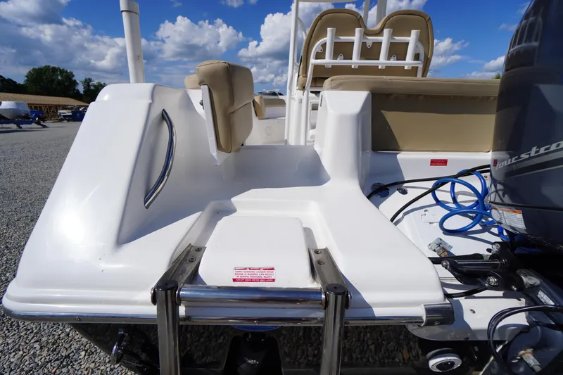 Slide: The Image of 2016 Tidewater 220 LXF boat stern view with seating and motor, under a blue sky. - 33