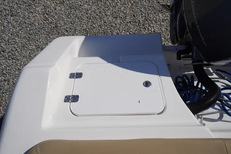 Slide: The Image of 2016 Tidewater 220 LXF boat deck with storage compartment and engine details. - 37