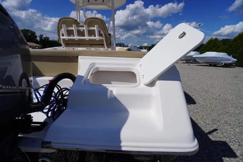 Slide: The Image of 2016 Tidewater 220 LXF boat with open storage compartment, under a clear blue sky. - 38