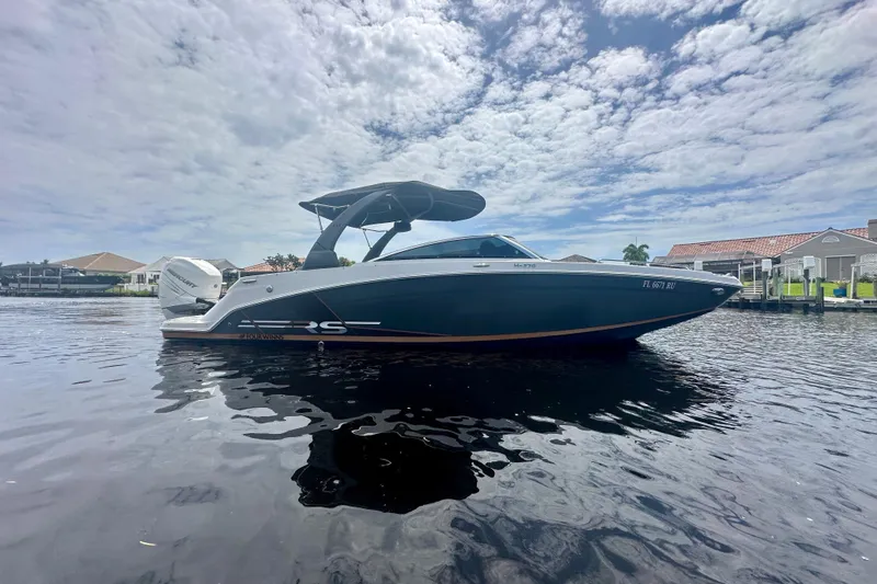 The Image of 2019 Four Winns HD270 OB boat on calm water under cloudy sky. - 0
