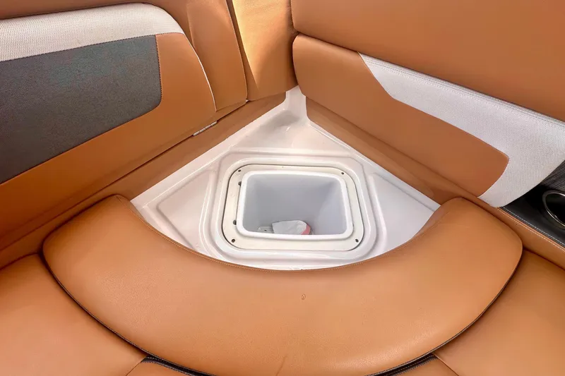Slide: The Image of 2019 Four Winns HD270 OB boat interior with tan seating and storage compartment. - 19