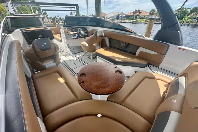 Slide: The Image of 2019 Four Winns HD270 OB boat interior with tan seating and wooden table. - 7