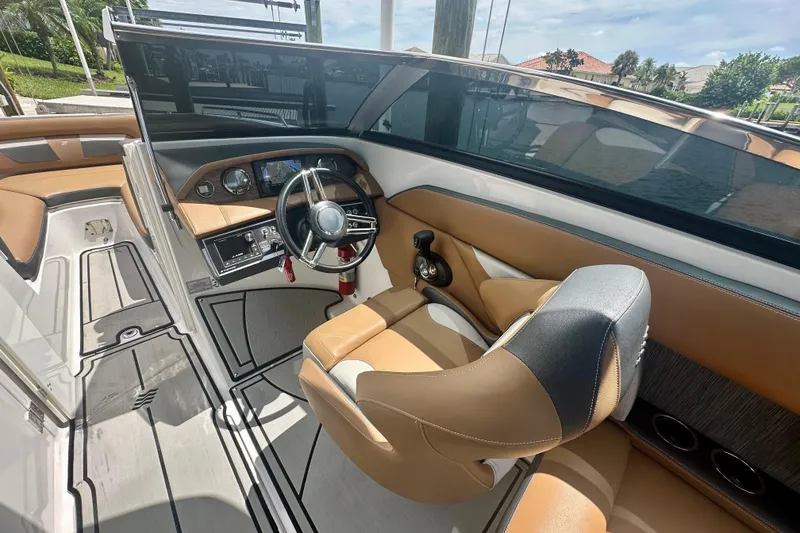 Slide: The Image of 2019 Four Winns HD270 OB boat interior with tan seating and modern dashboard. - 9