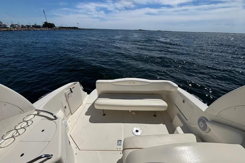 Slide: The Image of 2003 Sea Ray 280 Sundancer boat interior with seating, overlooking calm ocean waters. - 10