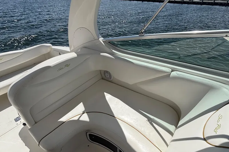 Slide: The Image of 2003 Sea Ray 280 Sundancer boat interior with white seating by the water. - 14