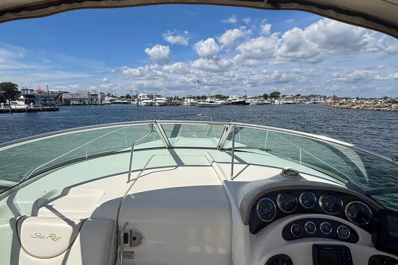 Slide: The Image of 2003 Sea Ray 280 Sundancer boat on water, clear sky, marina view. - 17
