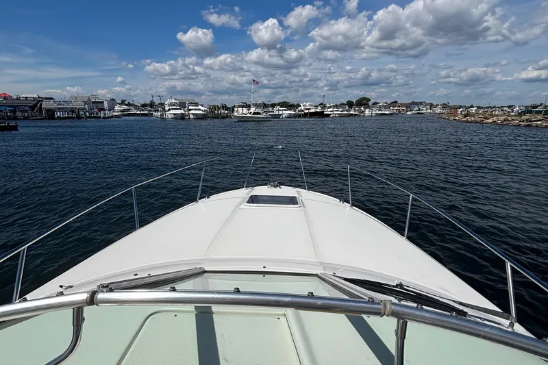 Slide: The Image of Bow view of 2003 Sea Ray 280 Sundancer approaching marina under cloudy sky. - 18