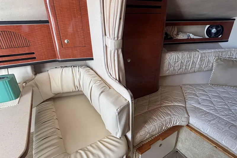 Slide: The Image of Interior of 2003 Sea Ray 280 Sundancer with cushioned seating and wood cabinetry. - 22