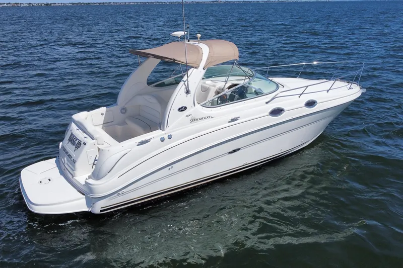Slide: The Image of 2003 Sea Ray 280 Sundancer boat cruising on open water, featuring sleek white design. - 3