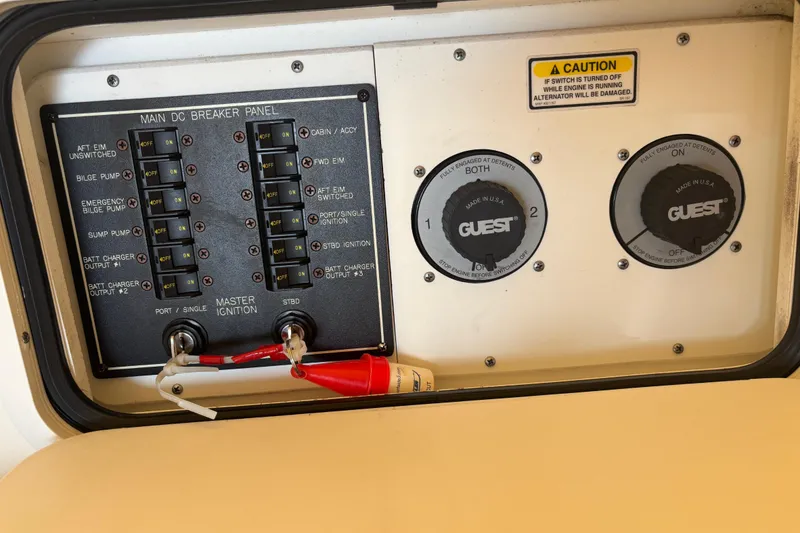 Slide: The Image of Main DC breaker panel on 2003 Sea Ray 280 Sundancer boat, featuring switches and caution label. - 33