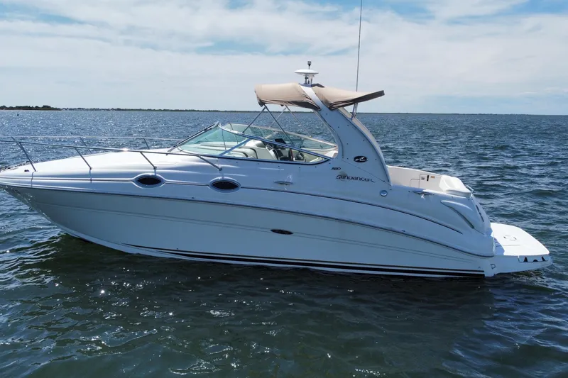 Slide: The Image of 2003 Sea Ray 280 Sundancer boat cruising on open water under a clear sky. - 4