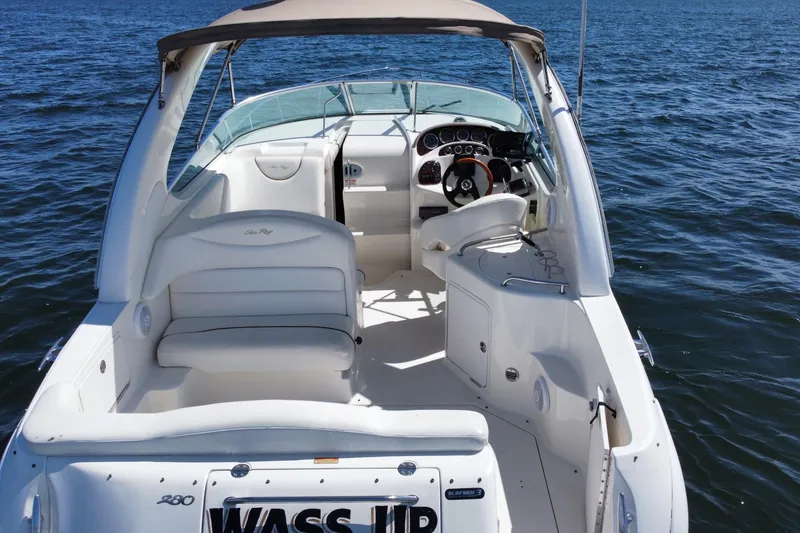 Slide: The Image of 2003 Sea Ray 280 Sundancer boat interior with seating and steering, on open water. - 6