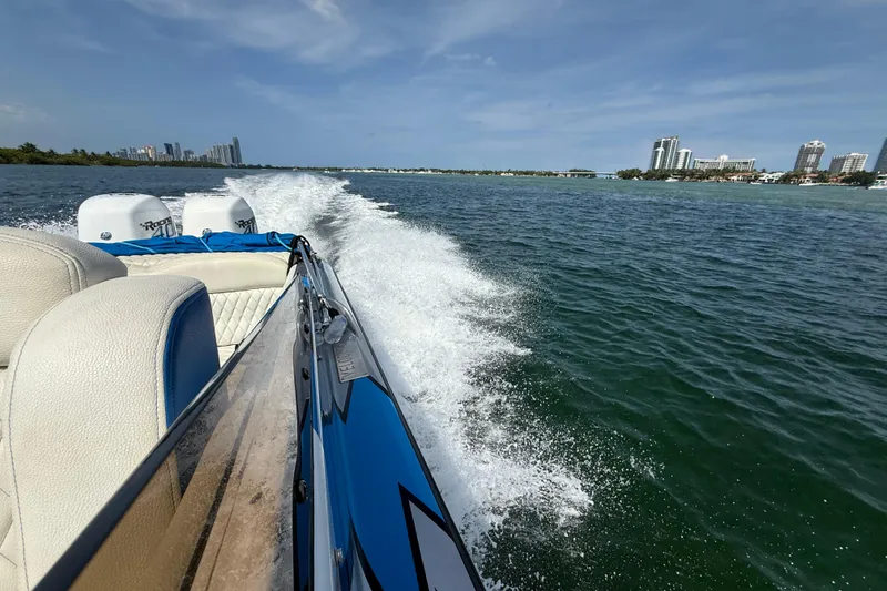 Slide: The Image of Velocity 290sc 2021 speedboat cruising on a sunny day with city skyline in background. - 29