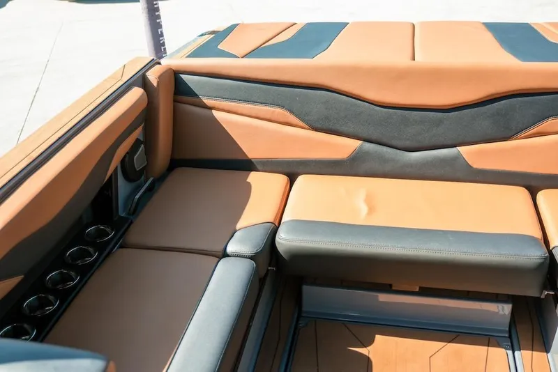 Slide: The Image of 2024 Axis T220 boat interior with tan and black seating, featuring cup holders. - 20