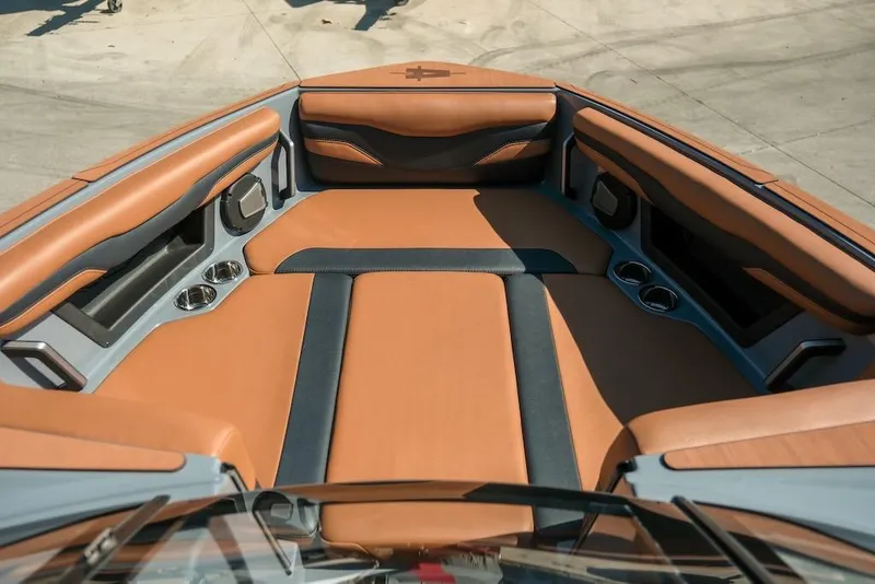 Slide: The Image of 2024 Axis T220 boat interior with tan and black seating, cup holders, and sleek design. - 23
