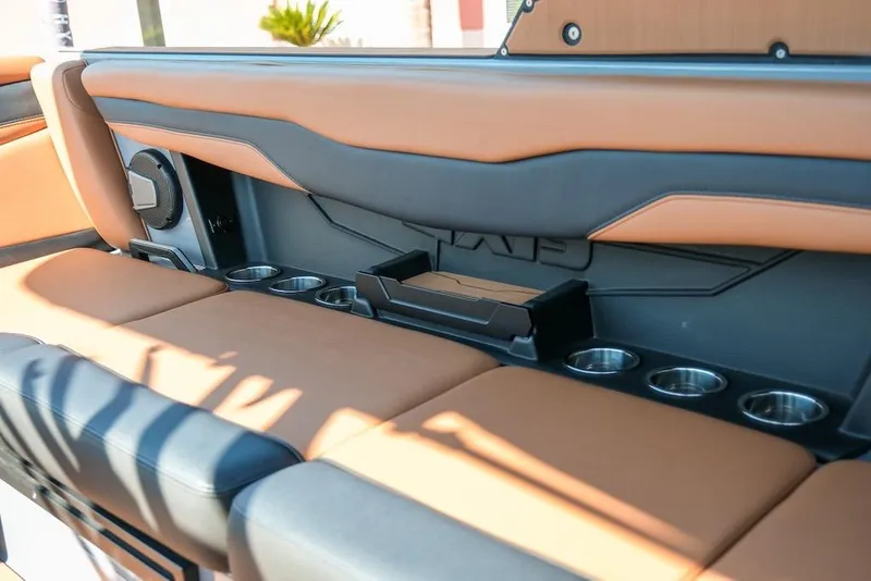 Slide: The Image of 2024 Axis T220 boat interior with tan and black seating, cup holders, and speaker. - 25