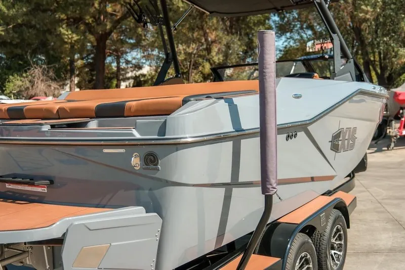 Slide: The Image of 2024 Axis T220 boat with sleek design and tan seating, parked outdoors. - 5