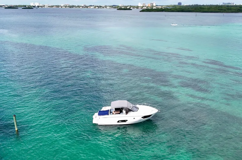 Slide: The Image of A 2014 Absolute 40 yacht cruising on clear turquoise waters near a distant shoreline. - 10