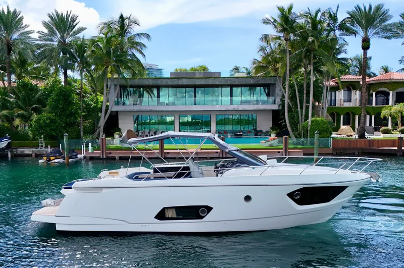 Slide: The Image of Luxury Absolute 40 yacht docked near modern waterfront mansion, surrounded by palm trees. - 23