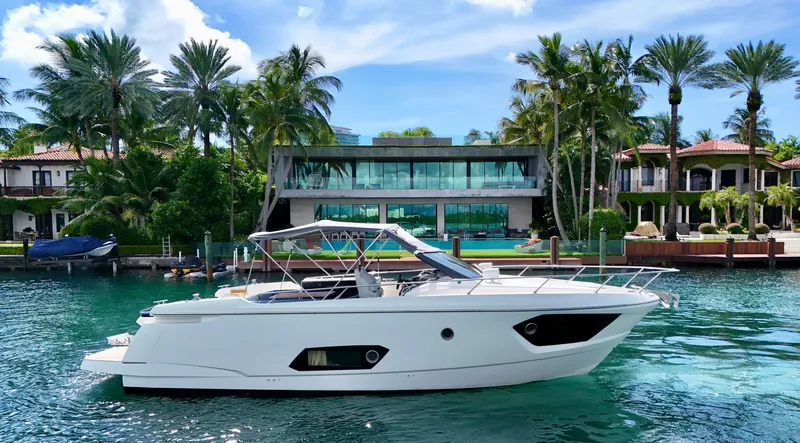Slide: The Image of Luxury Absolute 40 yacht cruising near waterfront mansion, surrounded by palm trees. - 27
