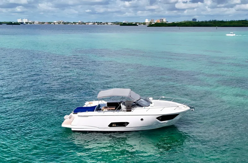 Slide: The Image of 2014 Absolute 40 yacht on turquoise water with city skyline in background. - 6