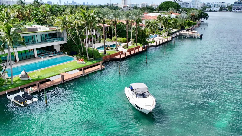 Slide: The Image of Luxurious waterfront property with a 2014 Absolute 40 yacht on turquoise waters. - 9