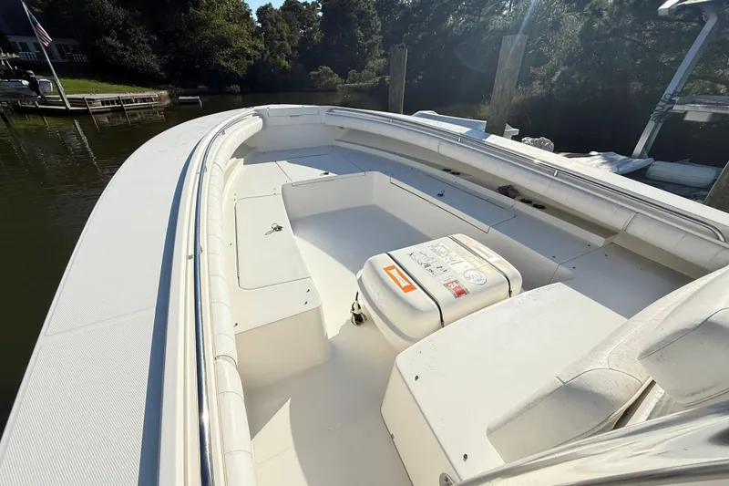 Slide: The Image of 2009 Regulator 34SS boat docked, showcasing spacious deck and seating under clear skies. - 16