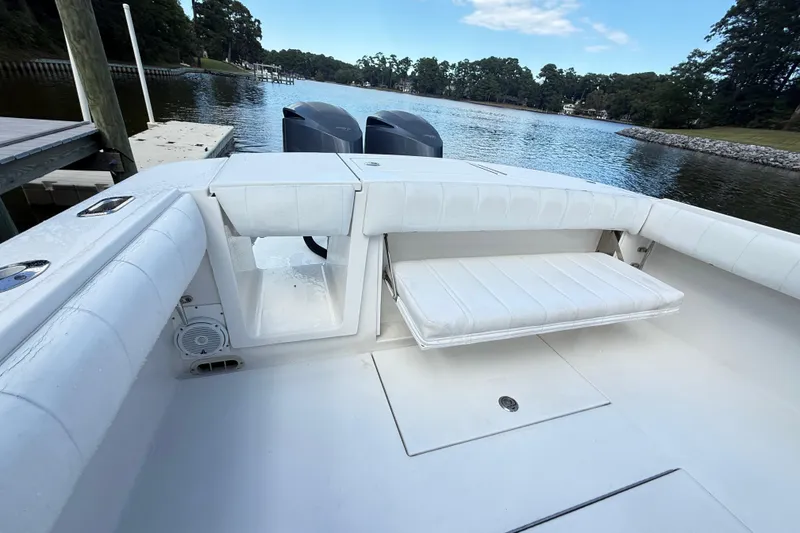 Slide: The Image of 2009 Regulator 34SS boat docked, featuring spacious deck and seating, surrounded by lush greenery. - 18