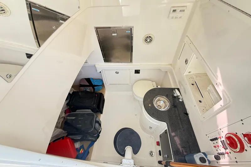 Slide: The Image of 2009 Regulator 34SS boat with fishing rod holders and navigation system, docked by a scenic shoreline. - 27