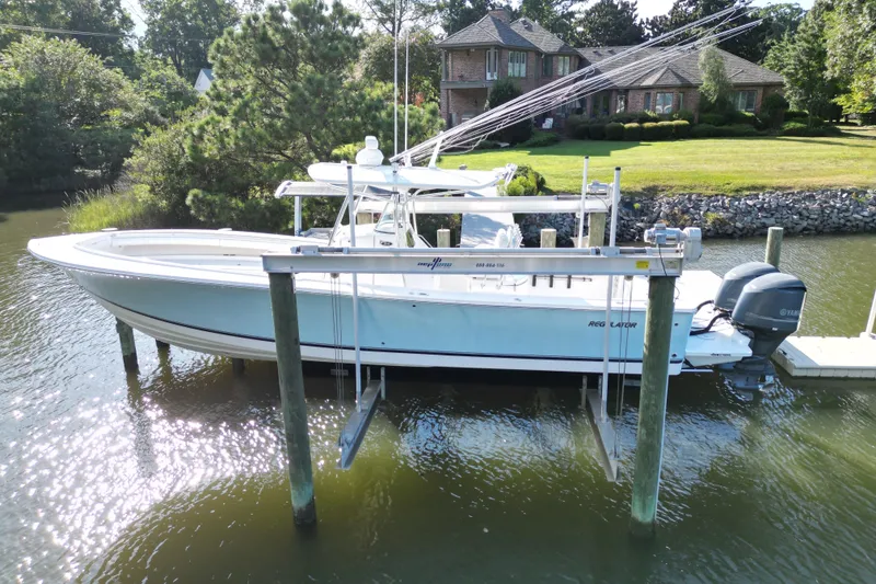 Slide: The Image of 2009 Regulator 34SS boat docked with Yamaha engines, clear sky, and waterfront house. - 3