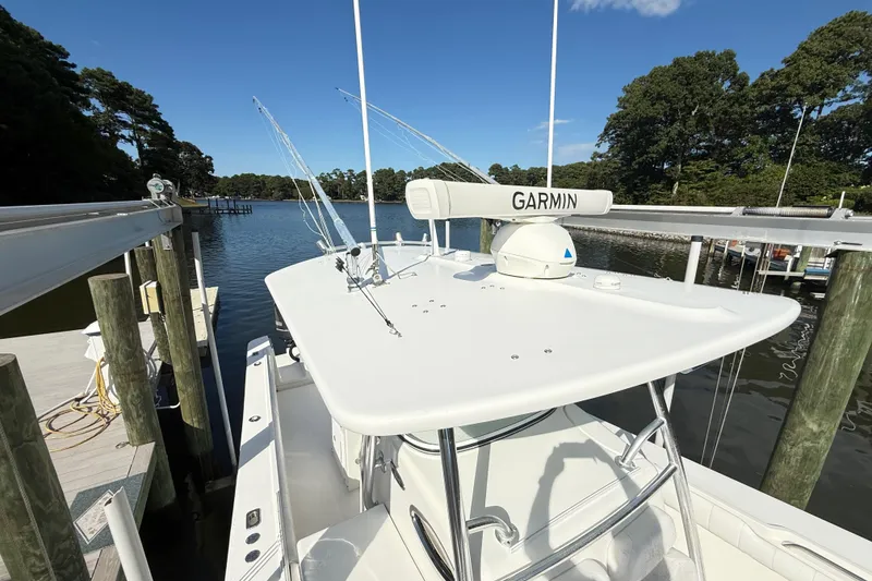 Slide: The Image of 2009 Regulator 34SS boat deck with railing, on calm water, surrounded by trees. - 32